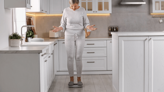 A woman standing on a scale struggling with menopause weight gain